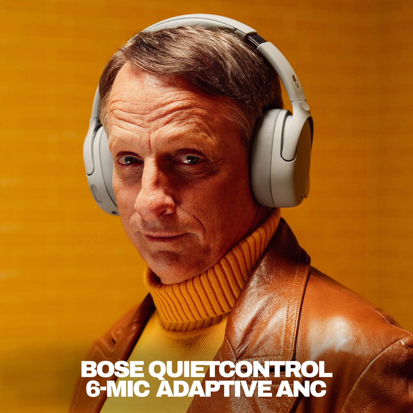 TOny Hawk wearing Skullcandy headphones with QuietControl with a warm background | Cement