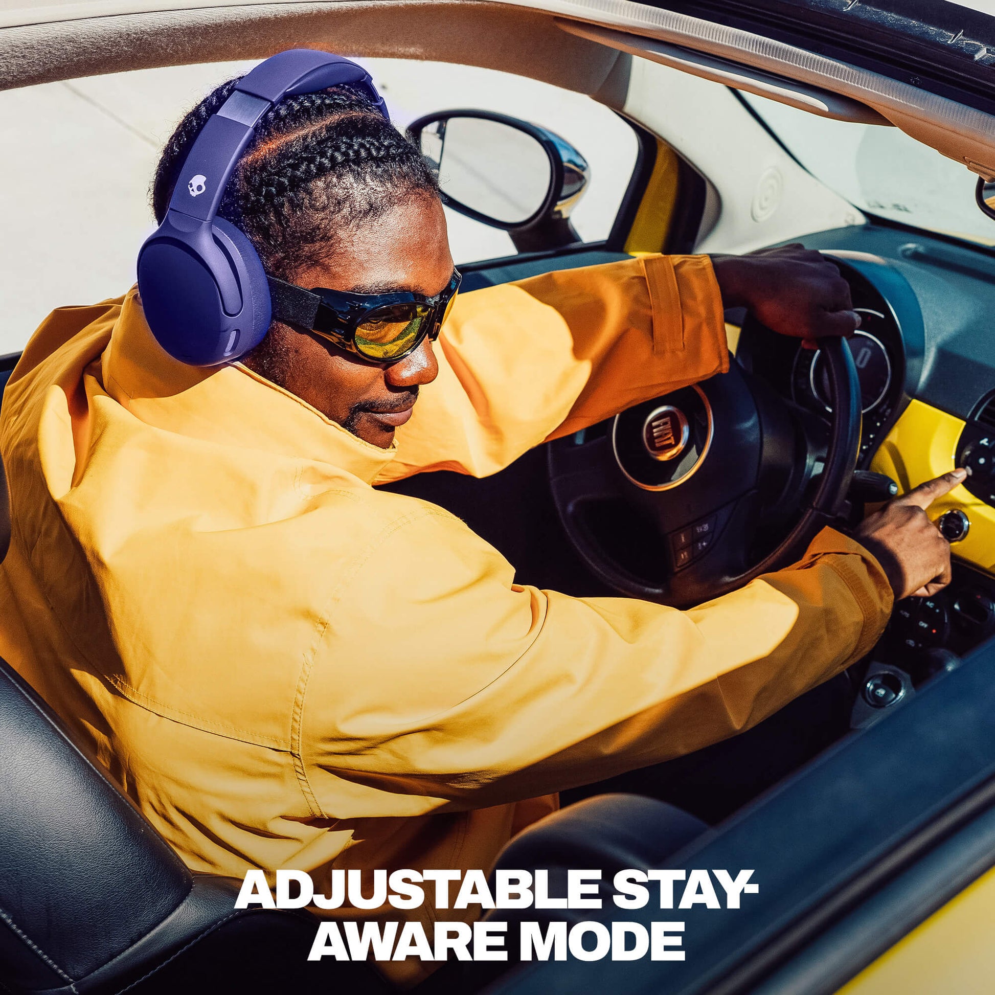 Person sitting in a car wearing Crusher 720 headphones and sunglasses with text 'Adjustable Stay Aware Mode'. | Future